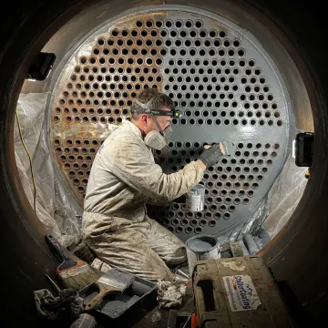 Technician applying protective heat exchanger coating