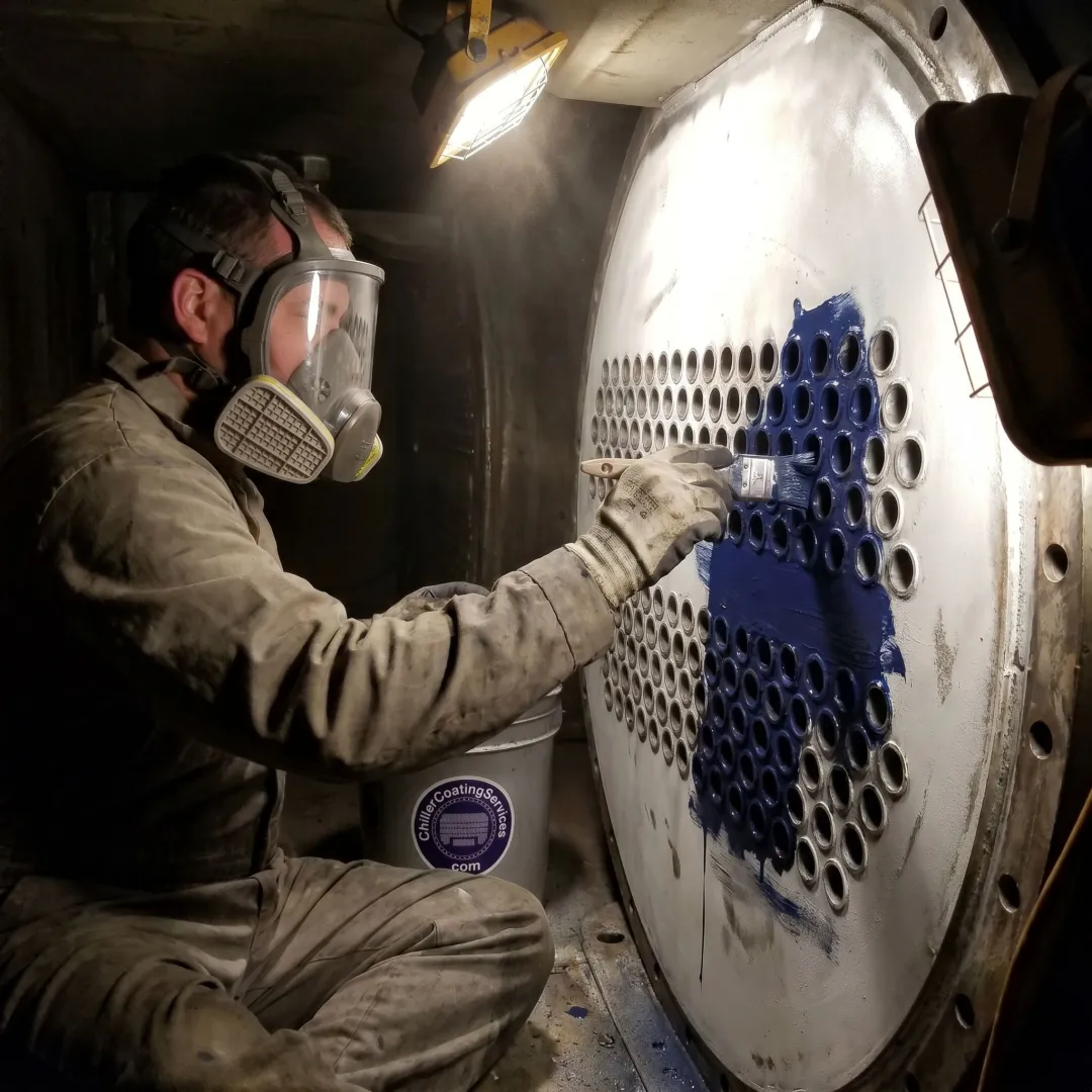 Technician coating a heat exchanger tube sheet