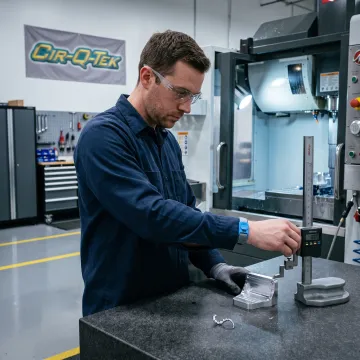 Technician inspecting a precision-machined component