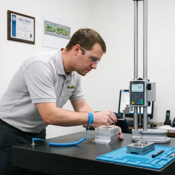 Technician inspecting a precision machined component