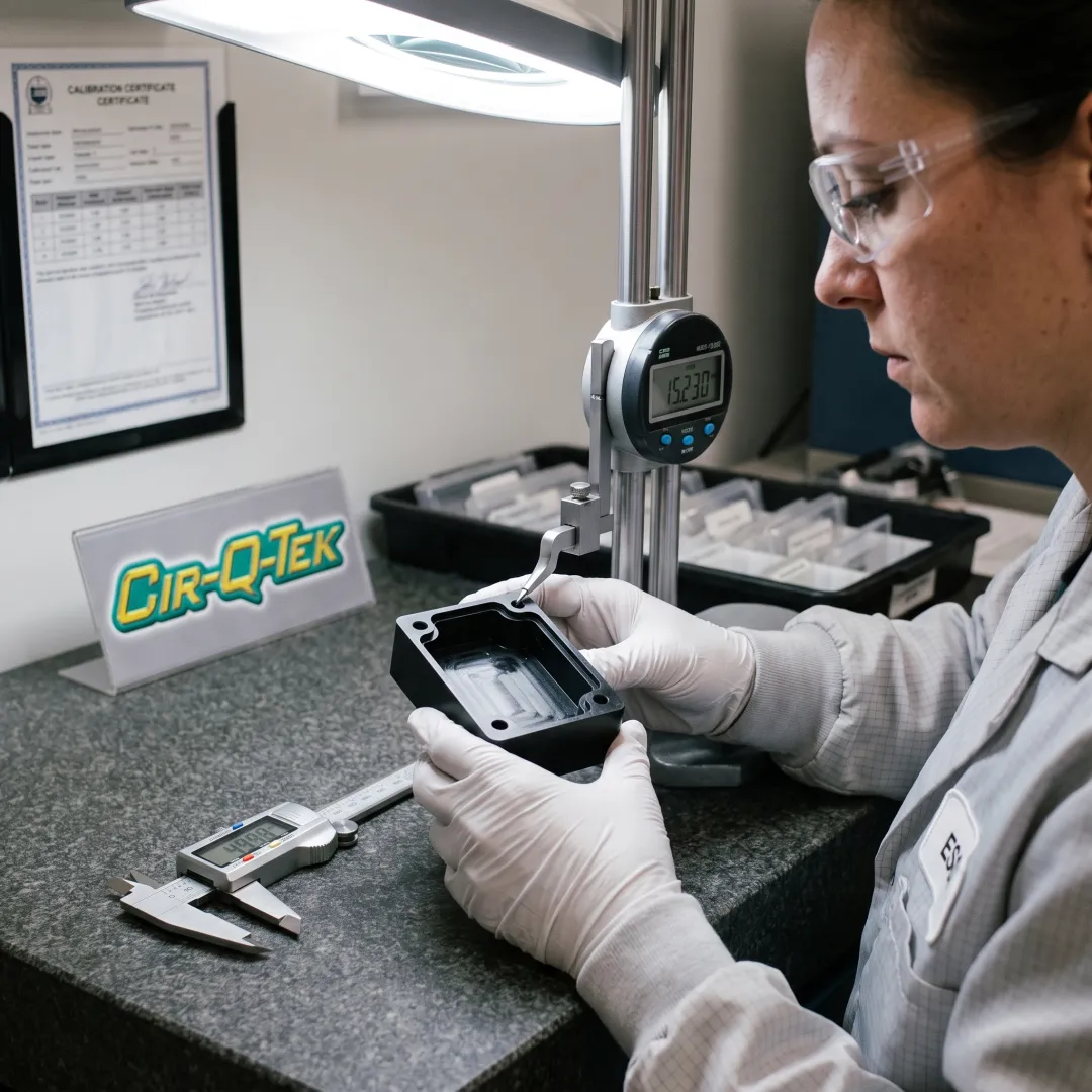 Technician inspecting a machined plastic part