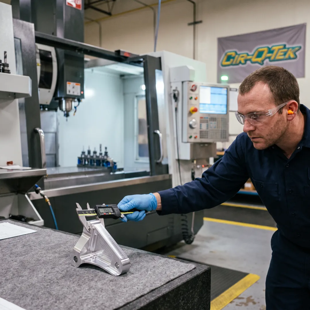 Technician inspecting a machined automotive part