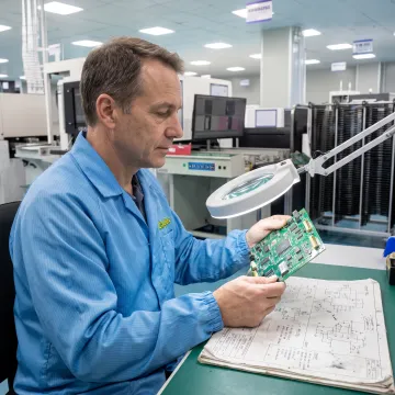 Engineer inspecting a printed circuit board