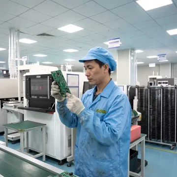 Technician inspecting a populated circuit board