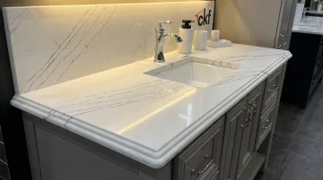 Quartz vanity countertop with matching backsplash in modern bathroom
