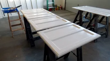 Freshly painted white kitchen cabinets with smooth factory-finish topcoat