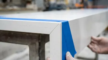 Quartz waterfall countertop miter joint installation showing epoxy seam bonding process