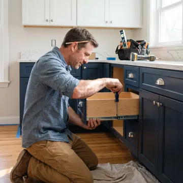 Cabinet installer adjusting pantry drawers
