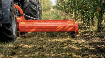 Flail mower mulching vegetation and depositing fine clippings onto field ground