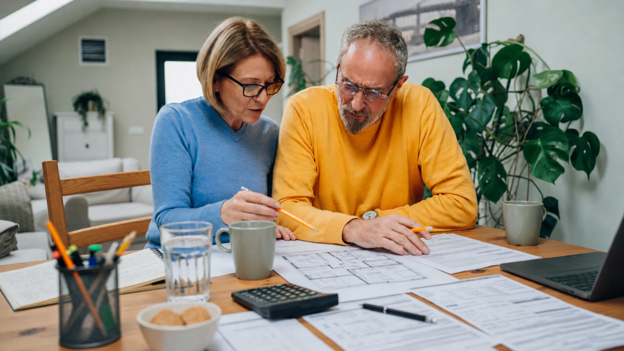 Homeowner reviewing renovation plans and finances at kitchen table