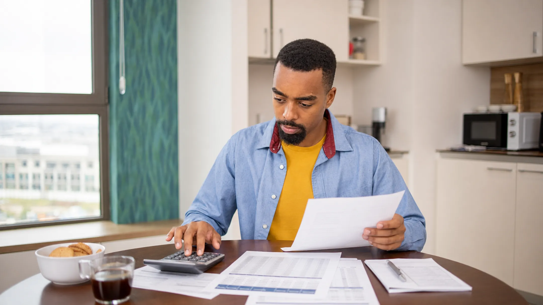 Homeowner reviewing fixed rate loan documents with calculator