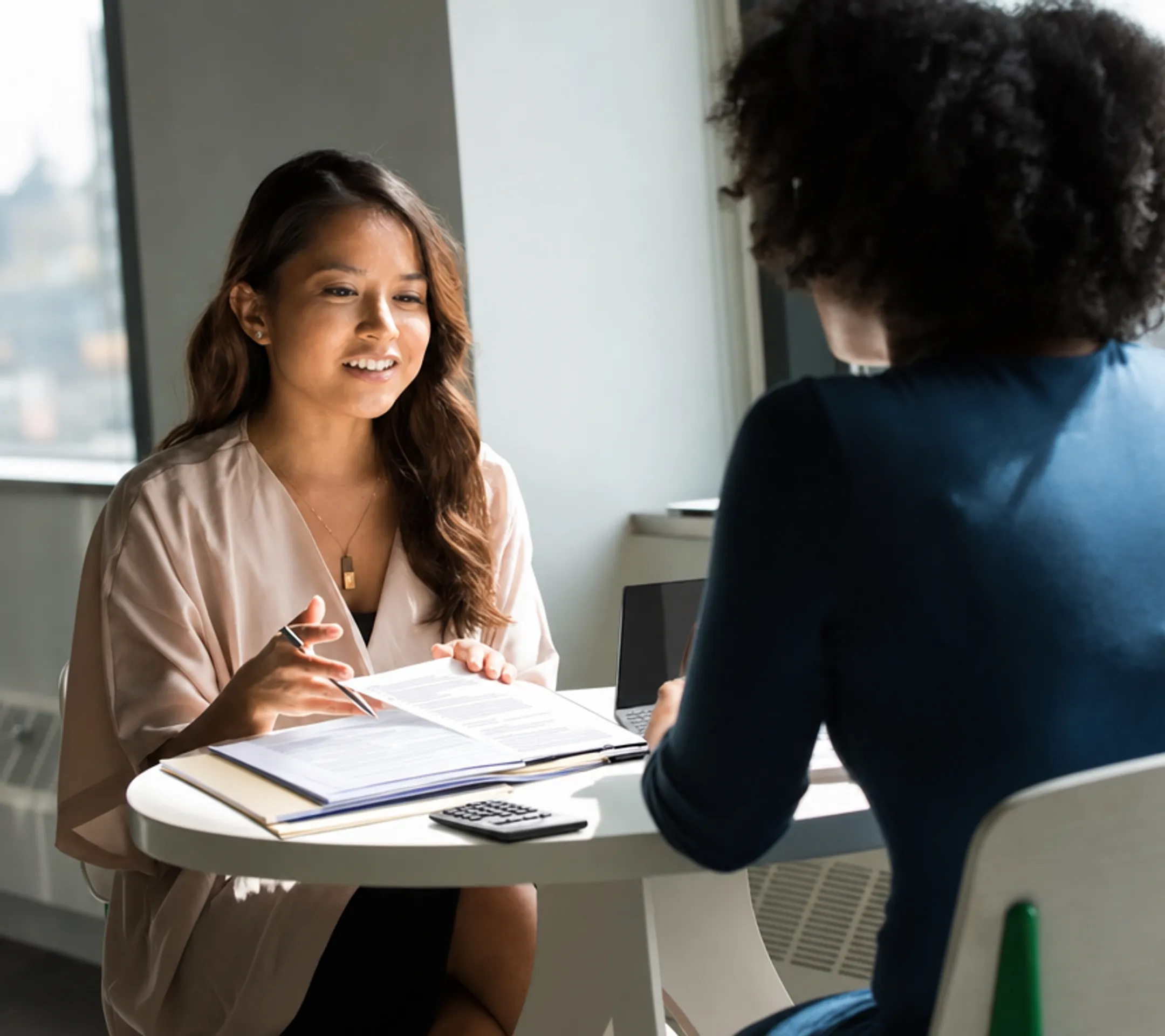 Loan officer reviewing mortgage underwriting documents with homebuyer client
