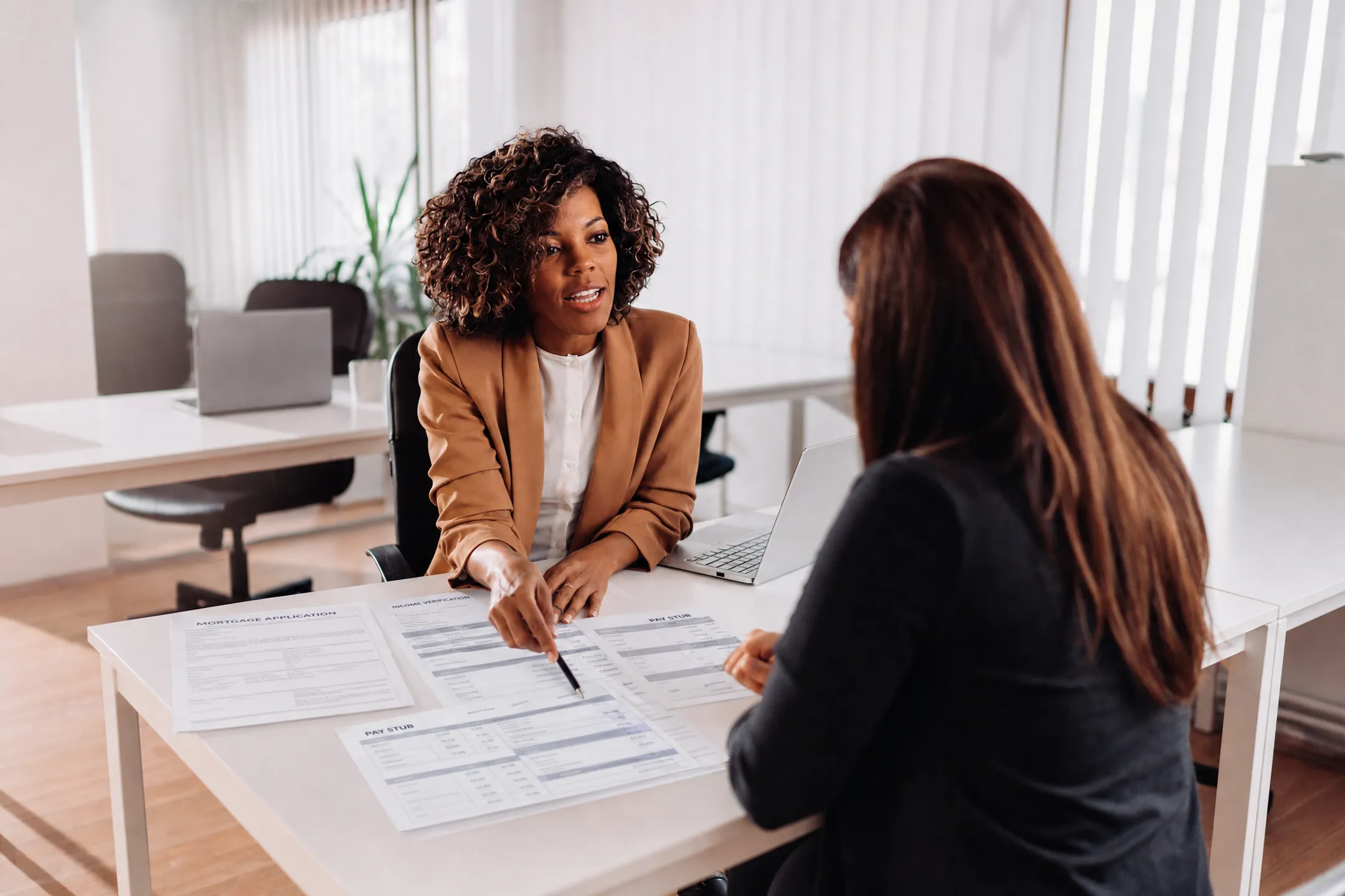 Loan officer reviewing mortgage documents with commission-based borrower