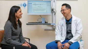 Physician using ambient AI scribe during patient encounter in clinical exam room