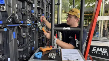 CMG Visuals technician repairing LED display module on-site