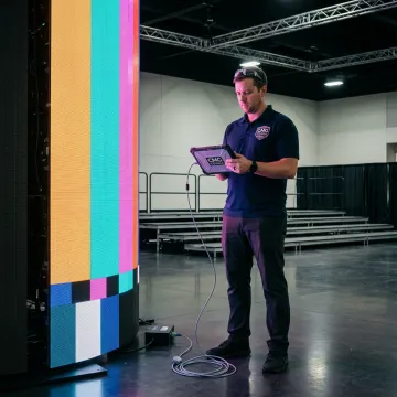 Technician calibrating a cylindrical LED display