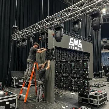 Technicians setting up an LED video wall for an event