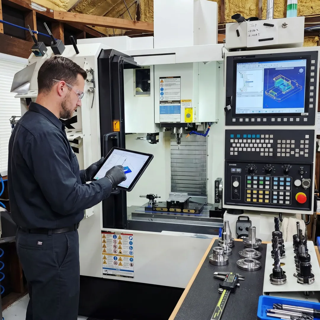 CNC machinist reviewing programmed part setup