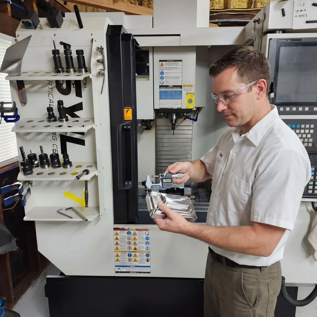 Technician reviewing a precision machined custom component