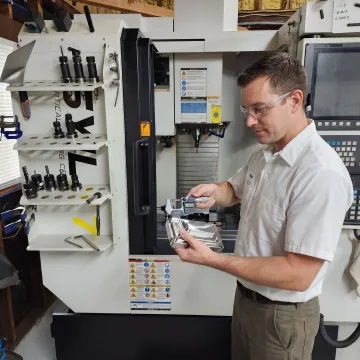 Technician reviewing a precision machined custom component