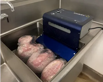 Commercial kitchen worker rapidly chilling large trays of prepared food for catering service