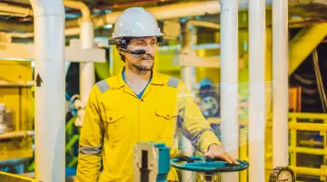 Field worker wearing RealWear AR headset inspecting industrial refinery equipment