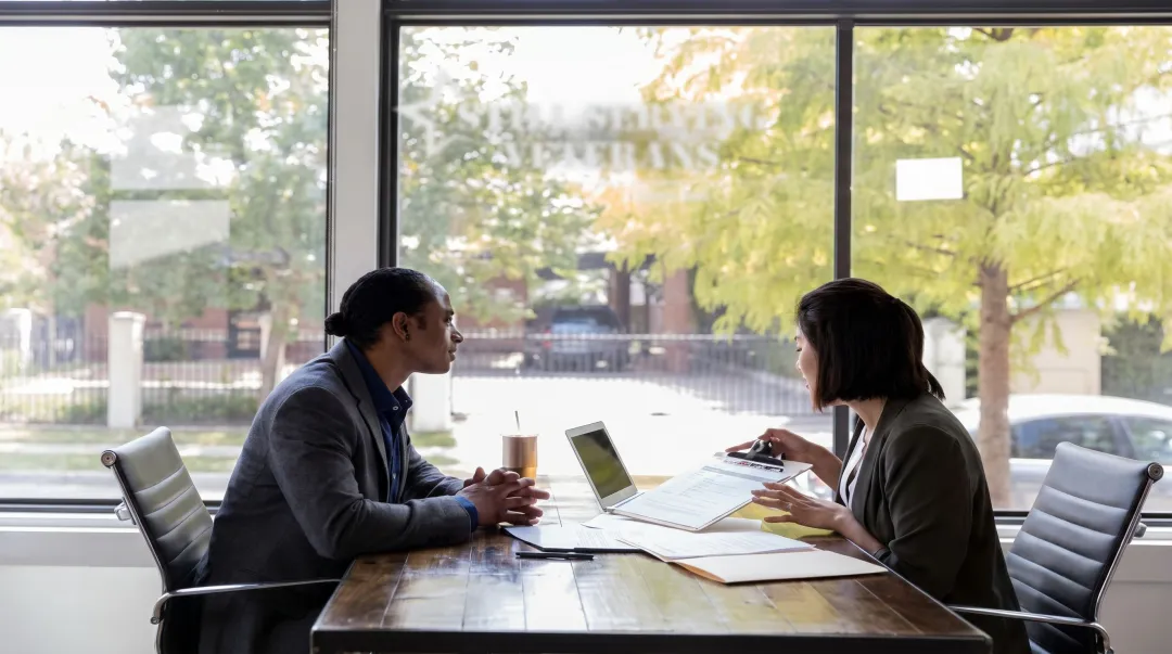 Veteran transitioning to civilian tech career with career counselor in professional office