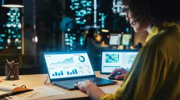 Data analyst reviewing business intelligence dashboard with charts and visualization metrics