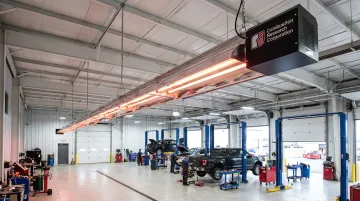 Ceiling-mounted infrared propane tube heater installed in a service garage bay