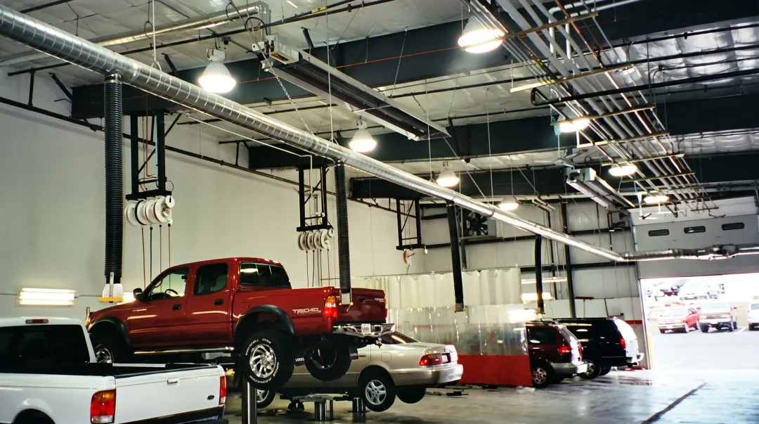 Auto dealership service bay with ceiling-mounted infrared tube heaters installed overhead