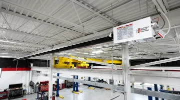 Natural gas infrared tube heater mounted on commercial garage ceiling
