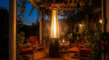 Propane pyramid glass tube patio heater glowing on outdoor restaurant terrace at night