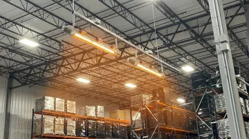 Industrial infrared radiant heater mounted in high-bay warehouse ceiling