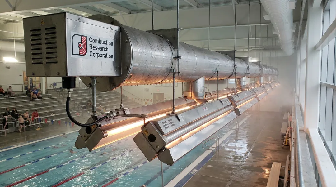 Stainless steel radiant tube heater installed above indoor pool deck