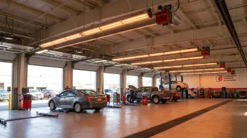 Ceiling-mounted industrial infrared tube heater installed in service garage
