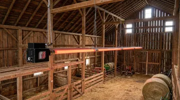 CRC infrared tube heater installed on barn ceiling above livestock area