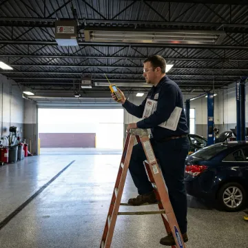 Technician reviewing infrared tube heater layout for a garage