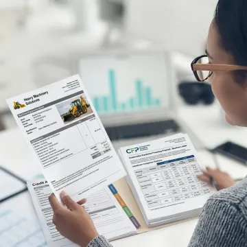 Finance specialist reviewing backhoe purchase documents