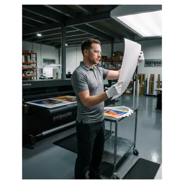 Print technician reviewing large format poster proofs