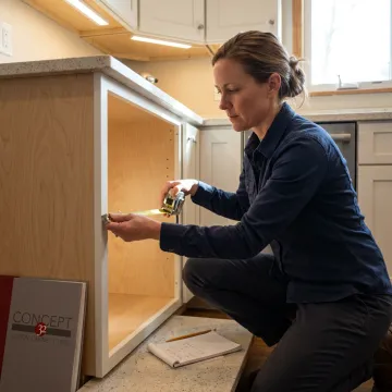 Designer measuring kitchen cabinet for pull out shelves