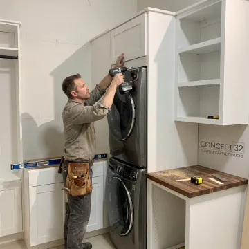 Cabinet installer fitting custom laundry room storage