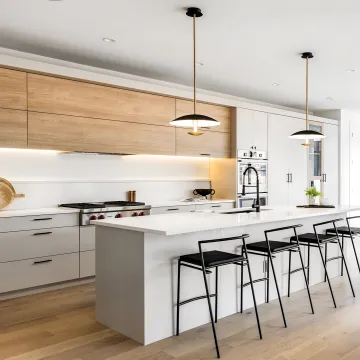 Designer reviewing kitchen cabinet plans with homeowners