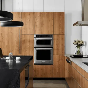 Designer reviewing kitchen cabinet plans with homeowners