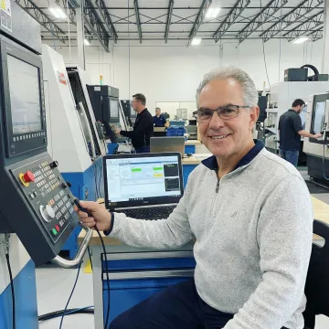 Engineering consultant integrating CNC machines with software systems in a manufacturing facility
