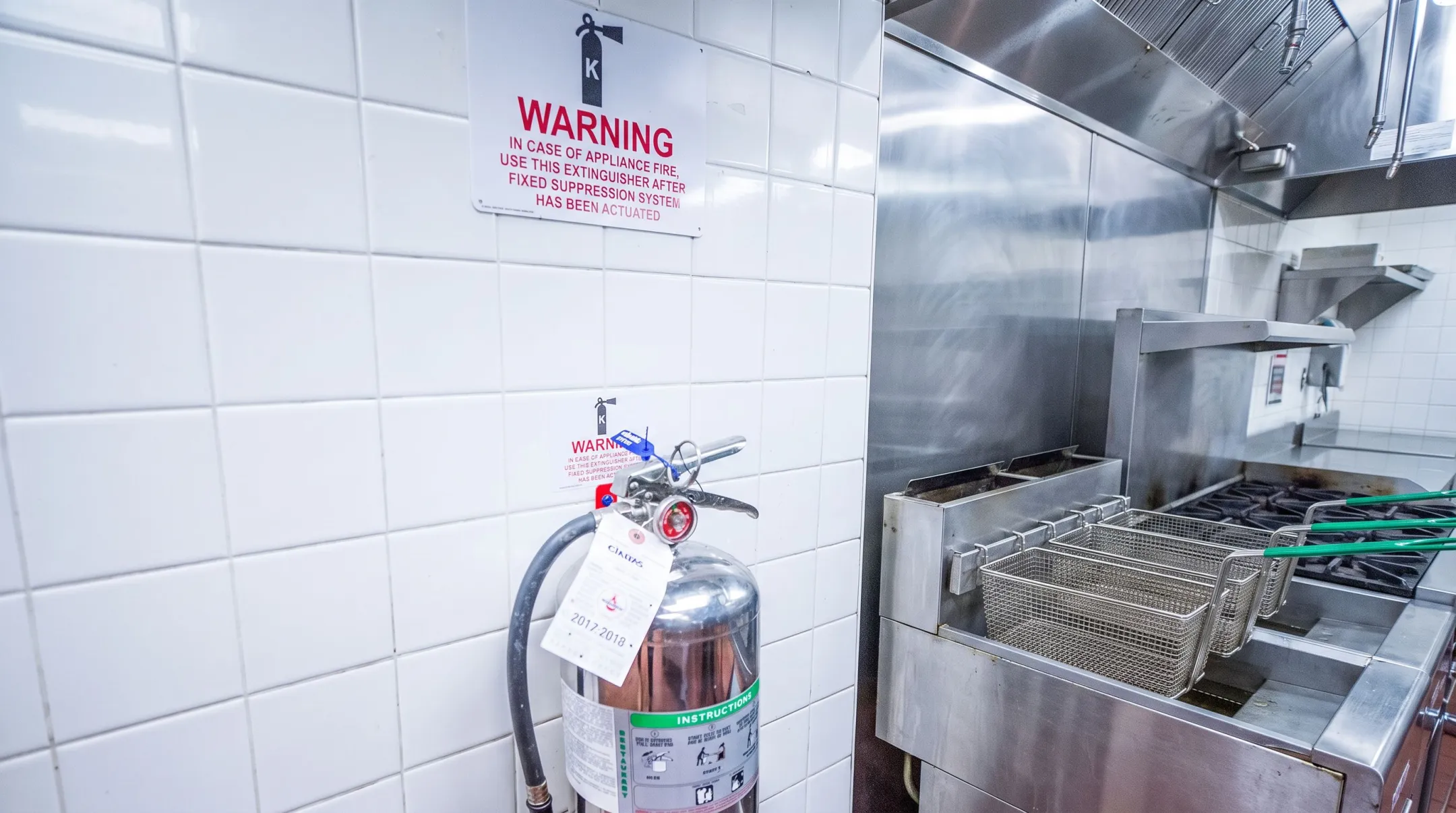 Commercial kitchen Class K sign mounted near fryer equipment