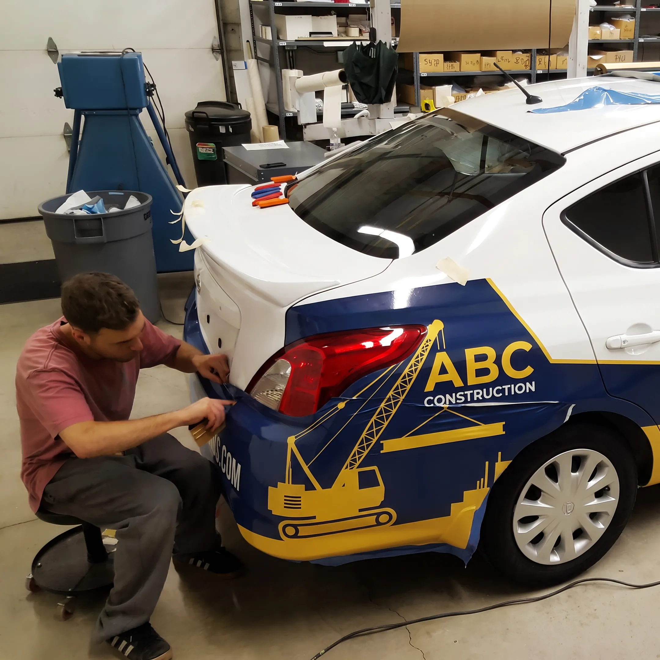Installer applying custom graphics to a branded construction vehicle