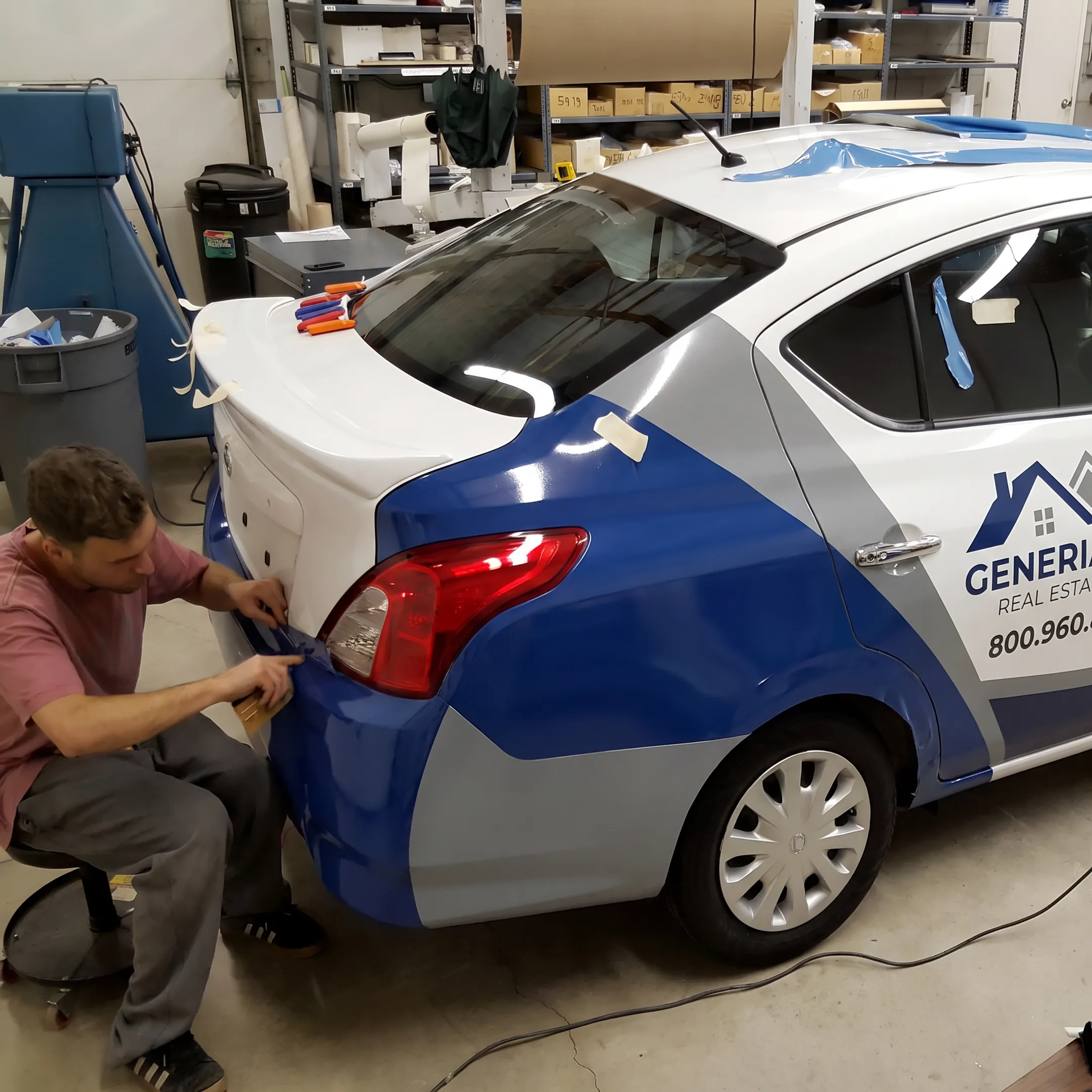 Professional installer applying branded graphics to a real estate vehicle