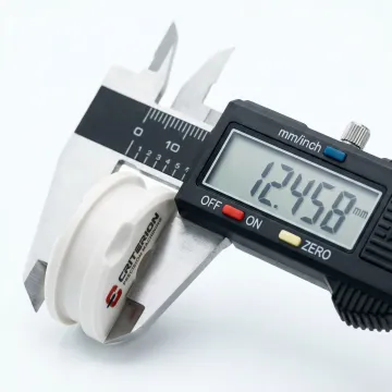 Close-up of precision-machined medical PEEK plastic component with measurement tools