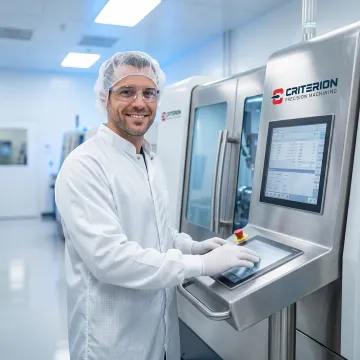 Precision machinist working on components inside a controlled cleanroom environment