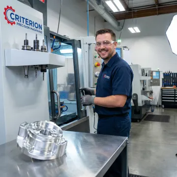 Precision machining technician operating a CNC multi-axis milling machine in a professional machine shop